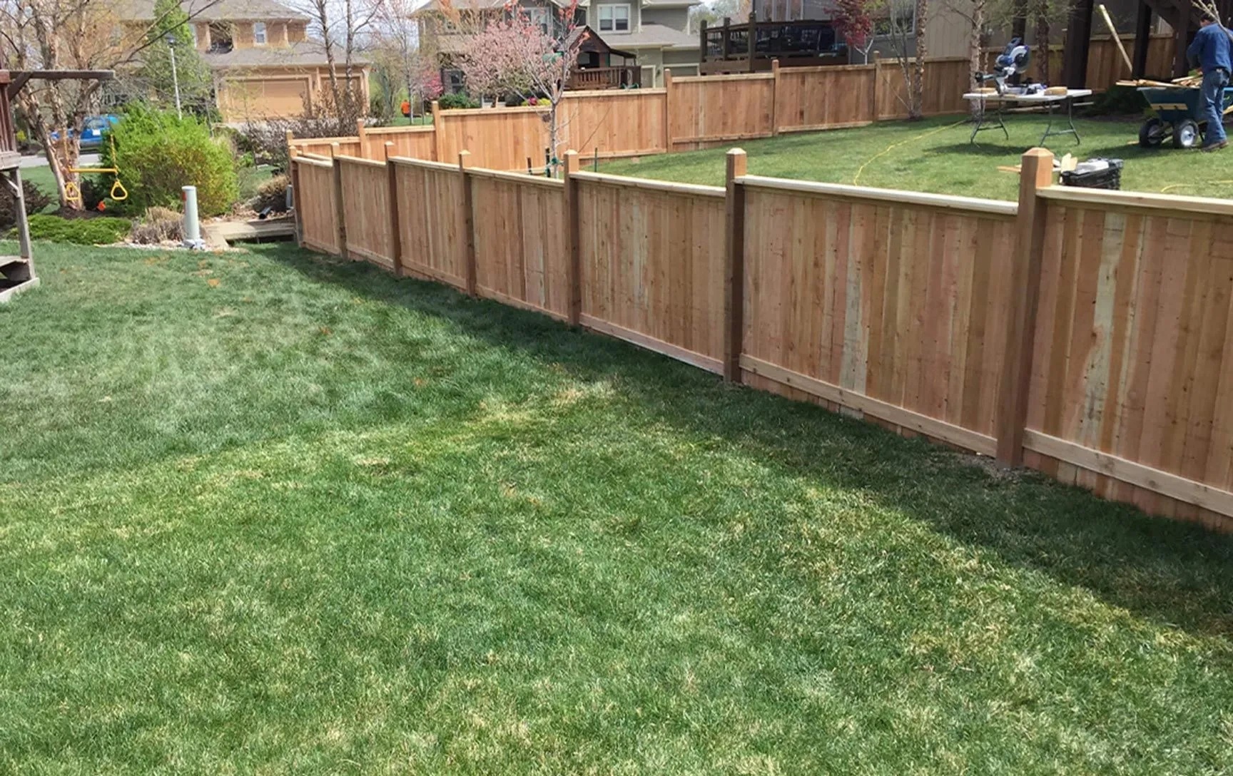 Cedar privacy fence following the edge of a landscaped backyard