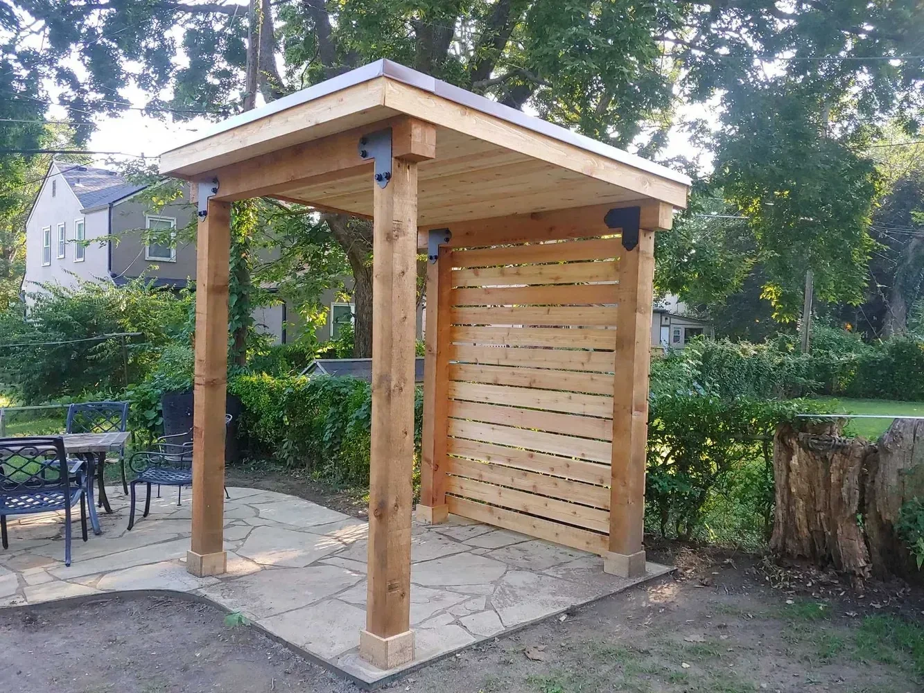 Cedar pergola with a horizontal privacy screen over a stone patio