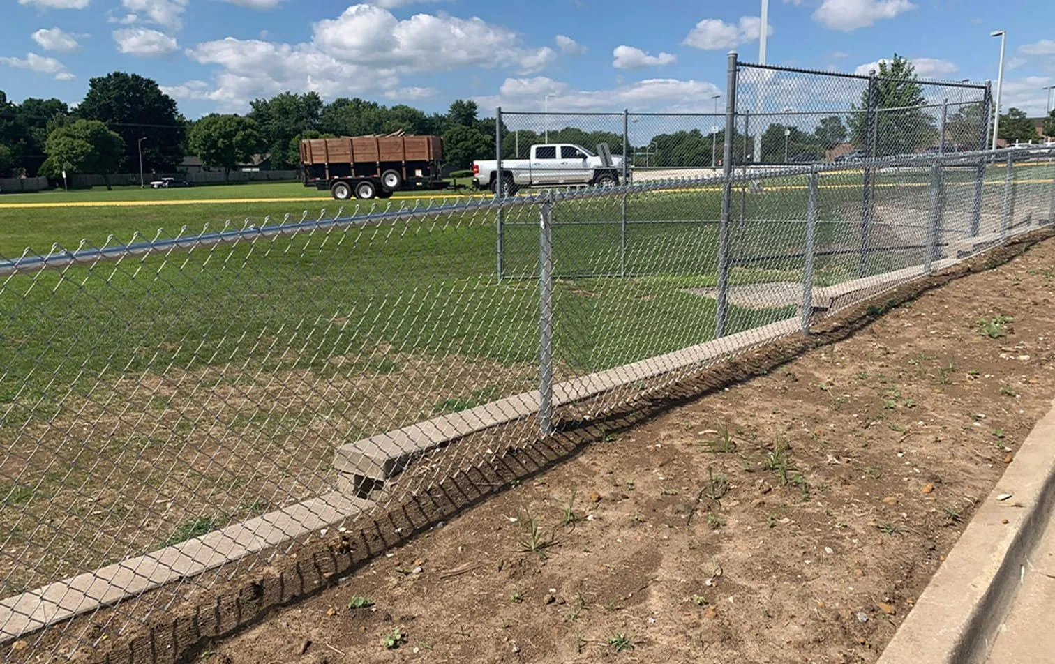 Commercial chain link fence and gate surrounding an athletic field