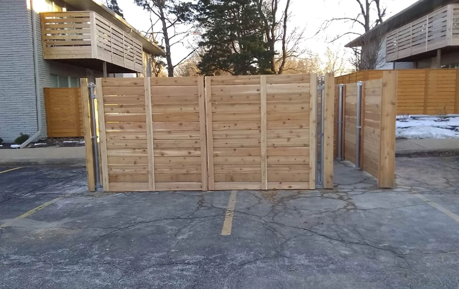 Commercial wood privacy enclosure with multiple gates and metal posts