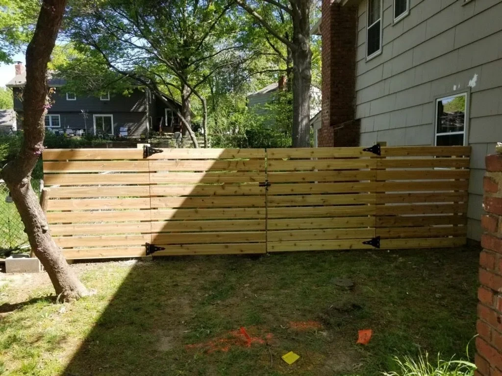 Horizontal wood double gate installed beside a home